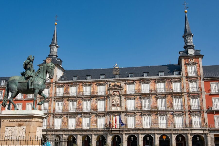 A statue of a man on a horse in front of a building